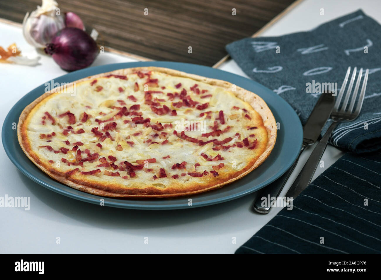 Taditional food `Tarte Flambee` or `Flammkuchen` from German-French Alsace border region. The name means `pie baked in the flames` Stock Photo